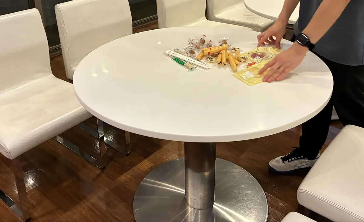 テーブルにおつまみを並べる参加者の手元